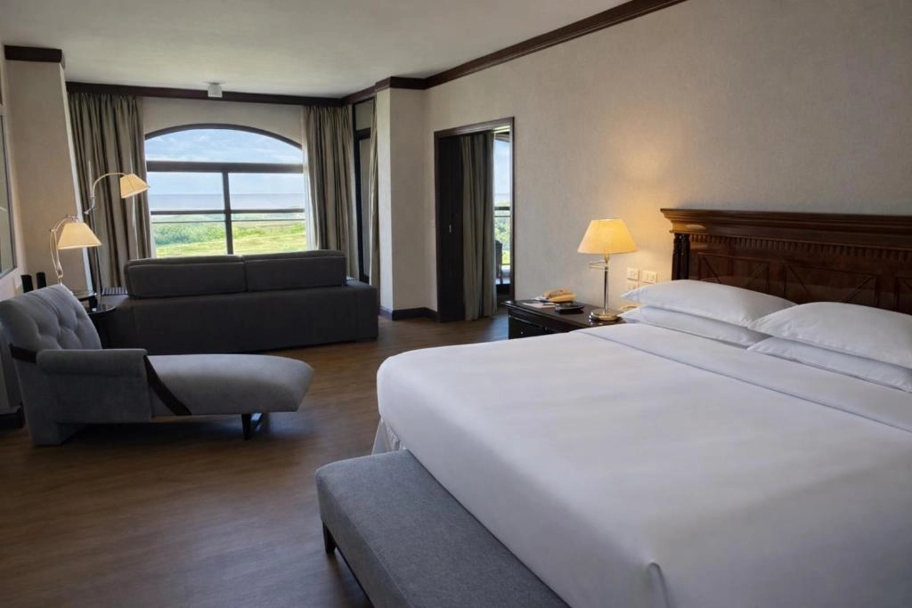dormitorio_cama_matrimonial_ventana_sheraton_colonia_golf_spa_resort.webp
