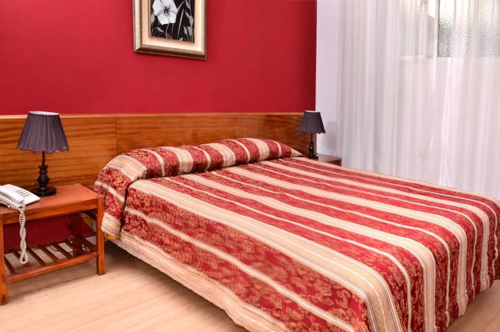 dormitorio_cama_mesas_de_luz_hotel_hispano.webp